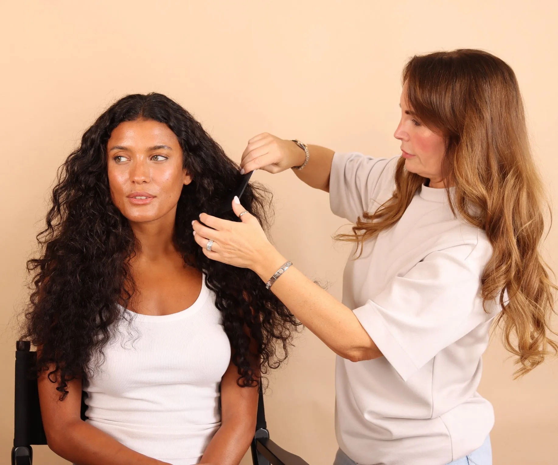 Official Remi Cachet Curl Collection photograph of a stylist working through long dark curls.