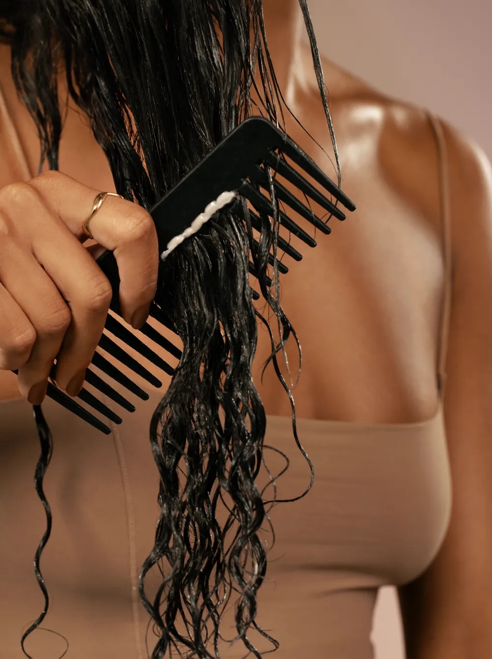Official Remi Cachet photograph showing a wide-tooth comb being used through wet curls.