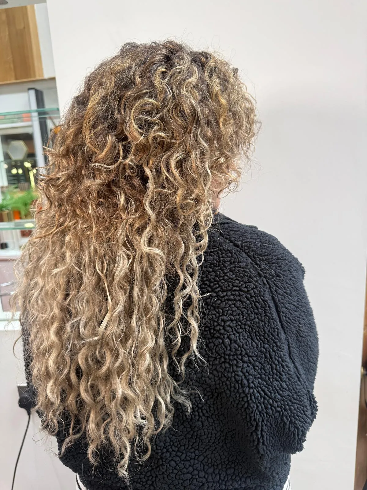 Back view of long blonde curly Remi Cachet extensions fitted by Claire at Wigs and Warpaint, Sheffield.